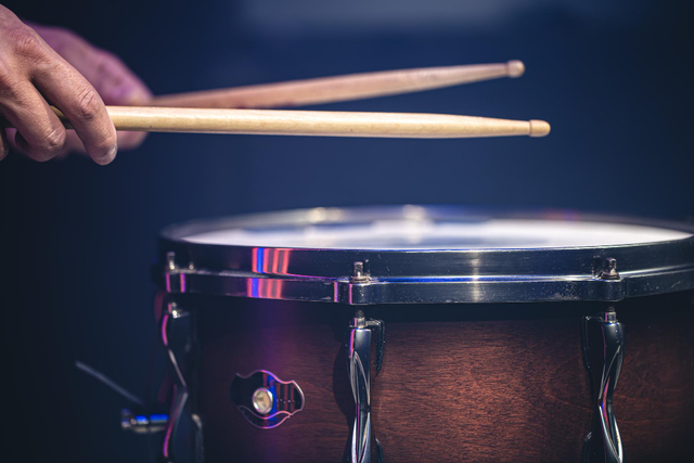 zoomed in picture of a drum kit with drum sticks