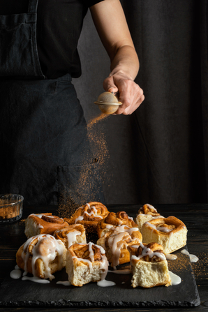pasticcere mette cannella su cinnamon rolls